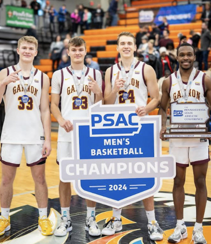 Student Golden Knight Basketball Athletes stand proud holding PSAC Championship sign.